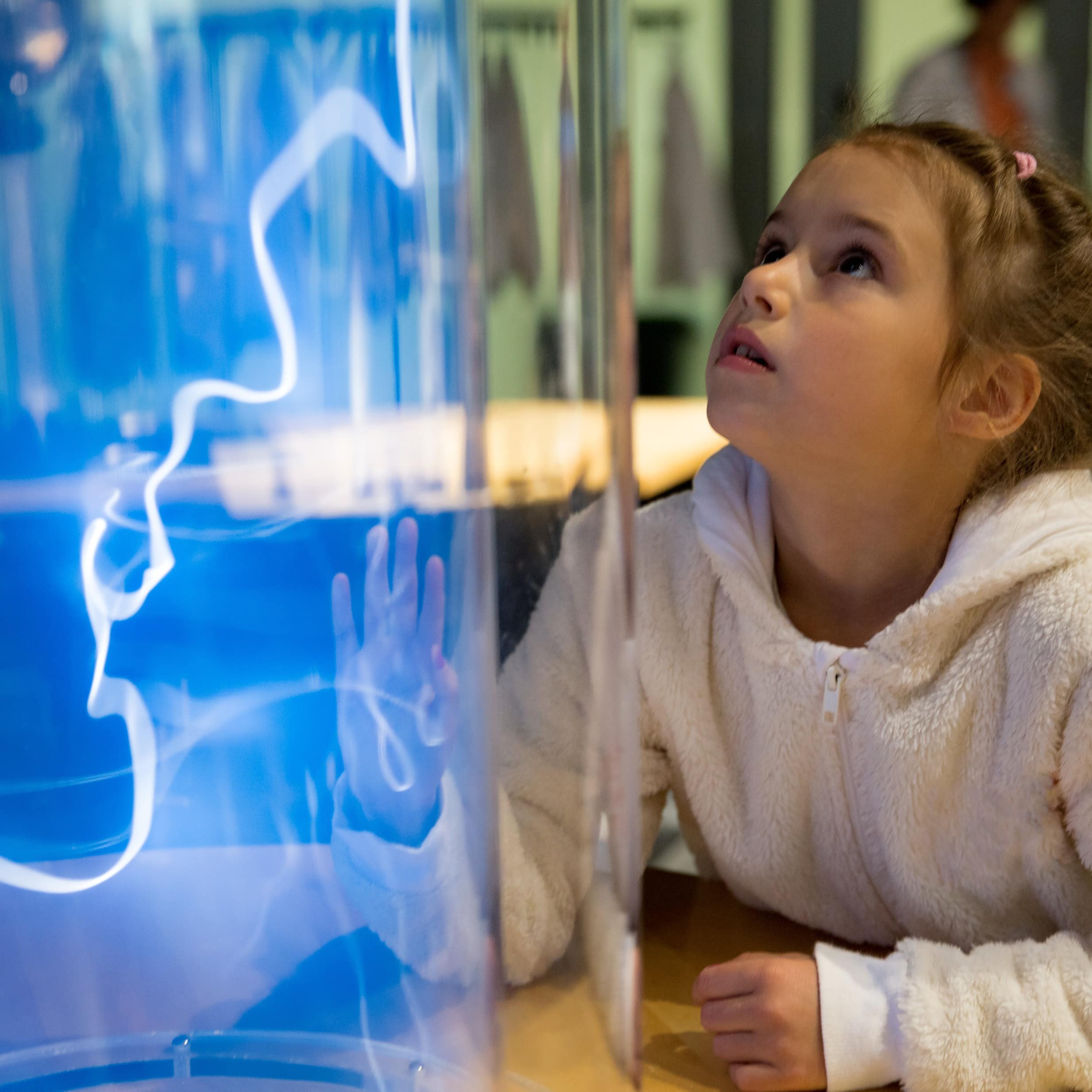 Little girl studying electrical discharges in a lab