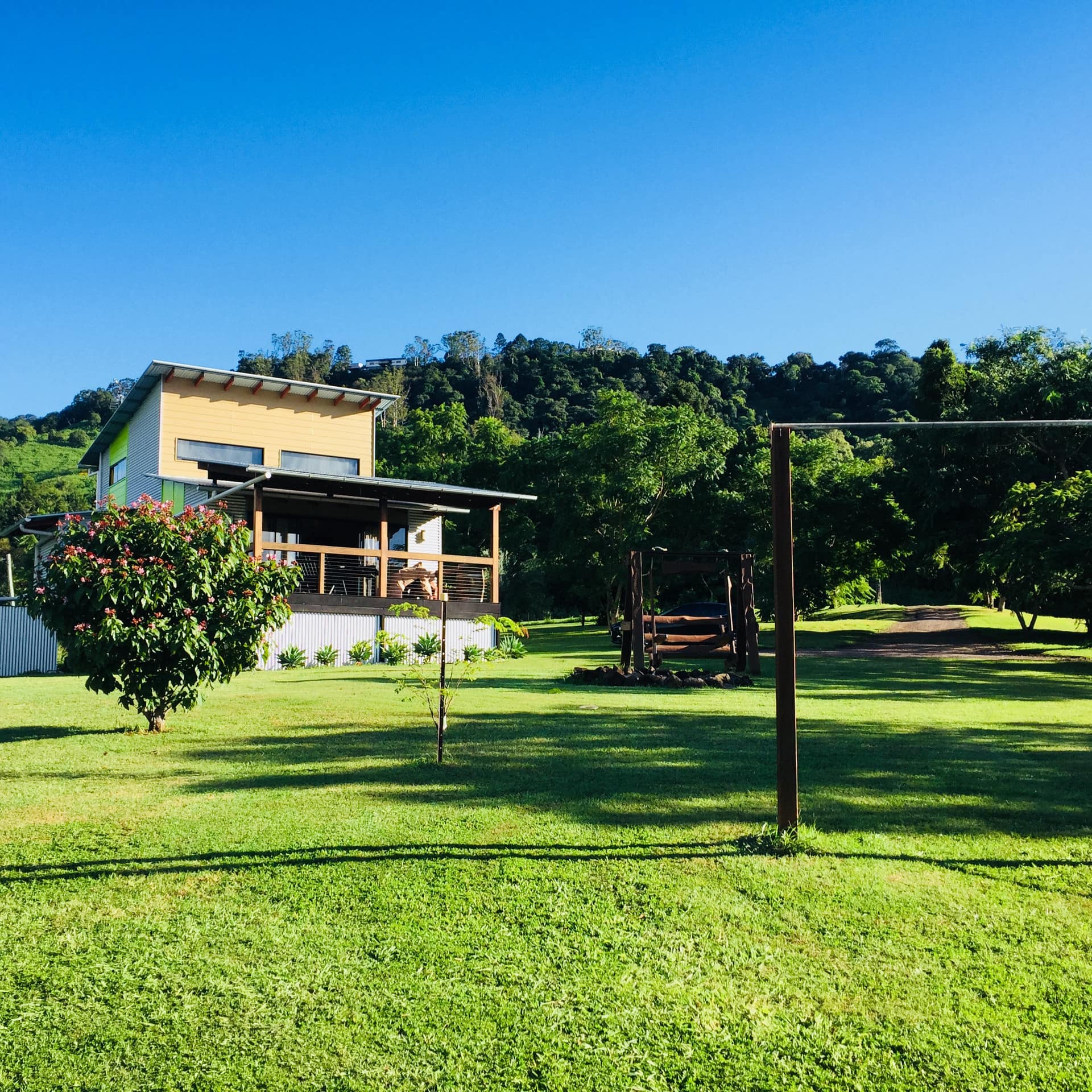 Boranup cabin with large windows and front porch looking out over rolling hills and handmade gym equipment