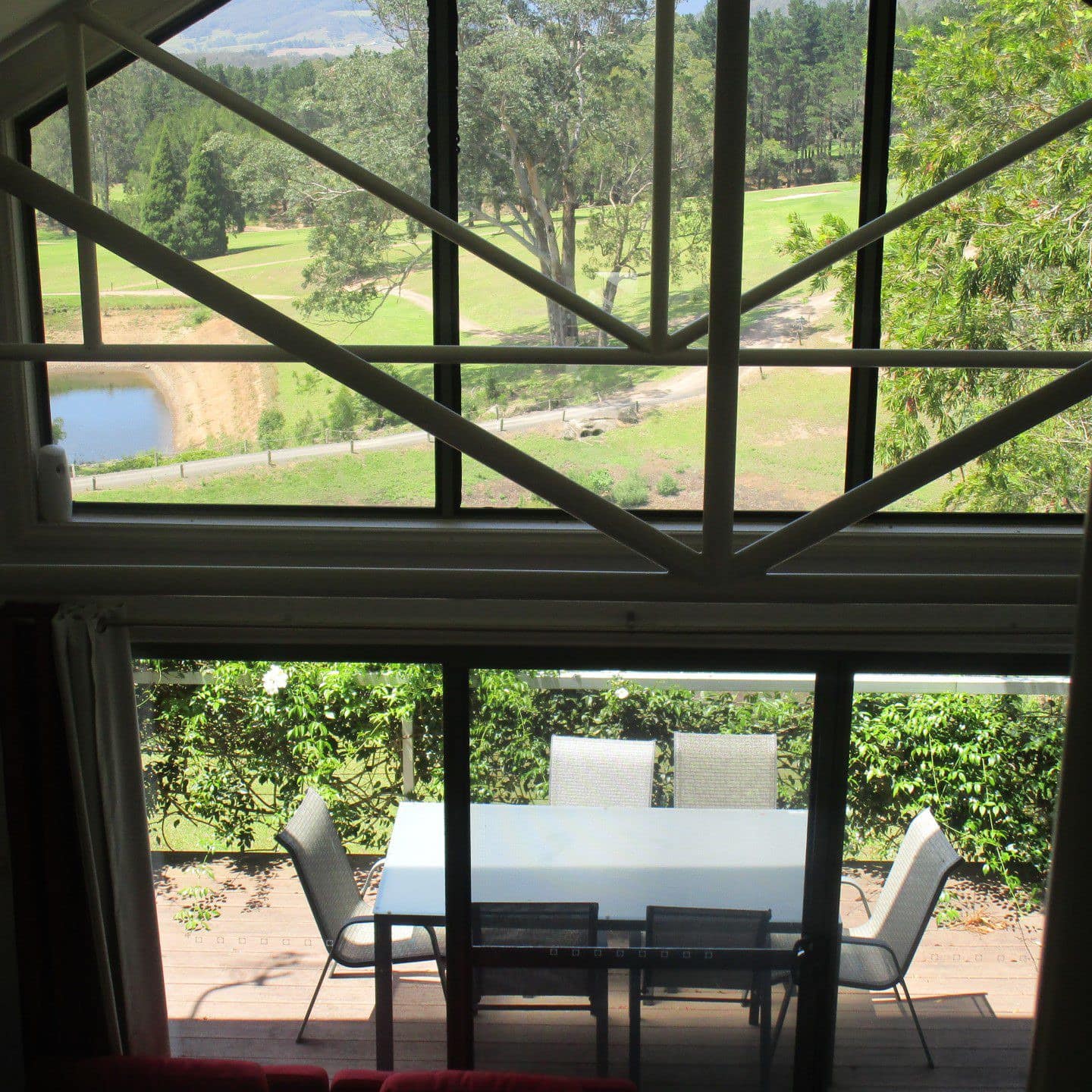 Outdoor dining area of 3-bedroom cabin shaded by trees with forested hillside in background