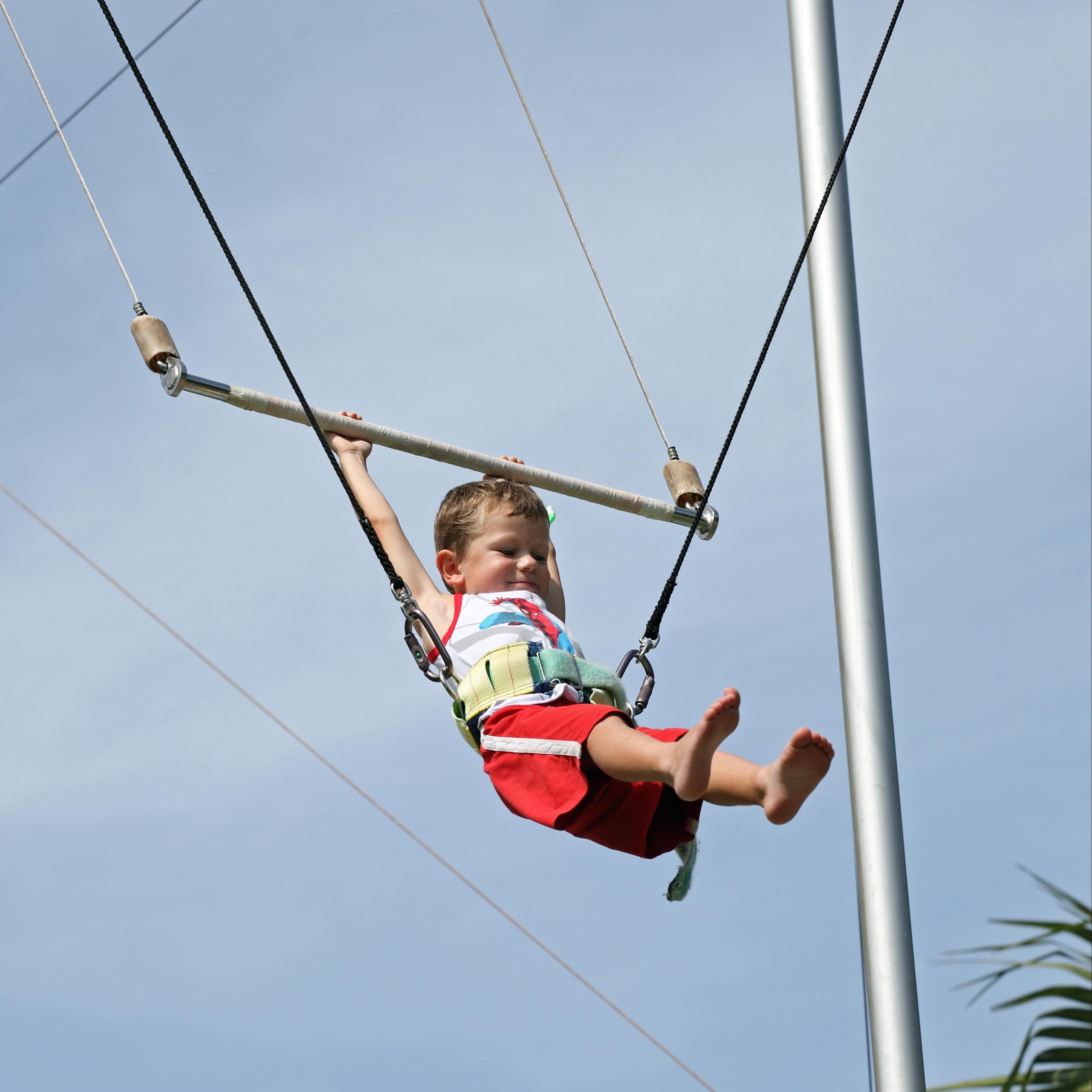 Young child learning to swing on trapeze