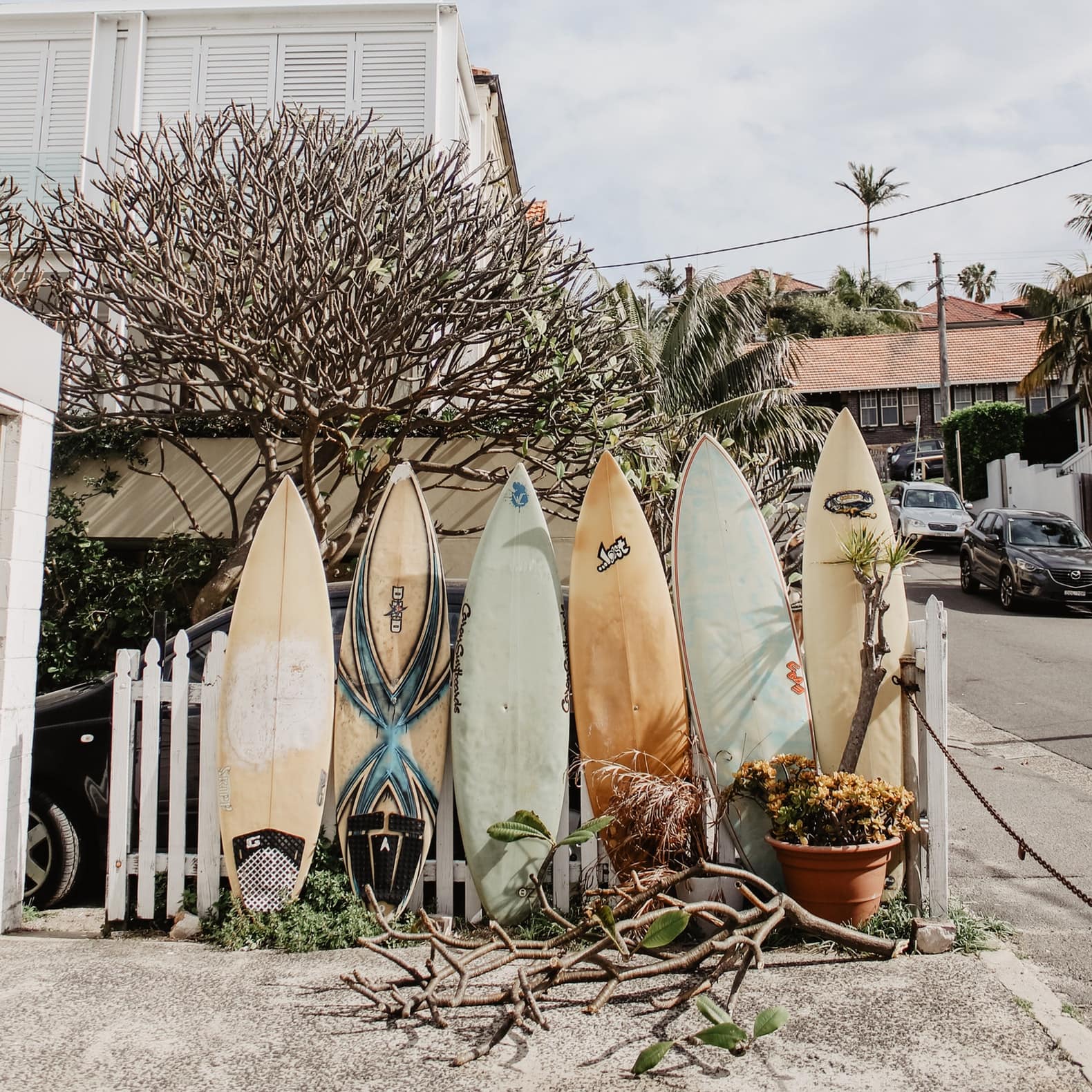 Surfboards resting against a fence in front of a beachside apartment