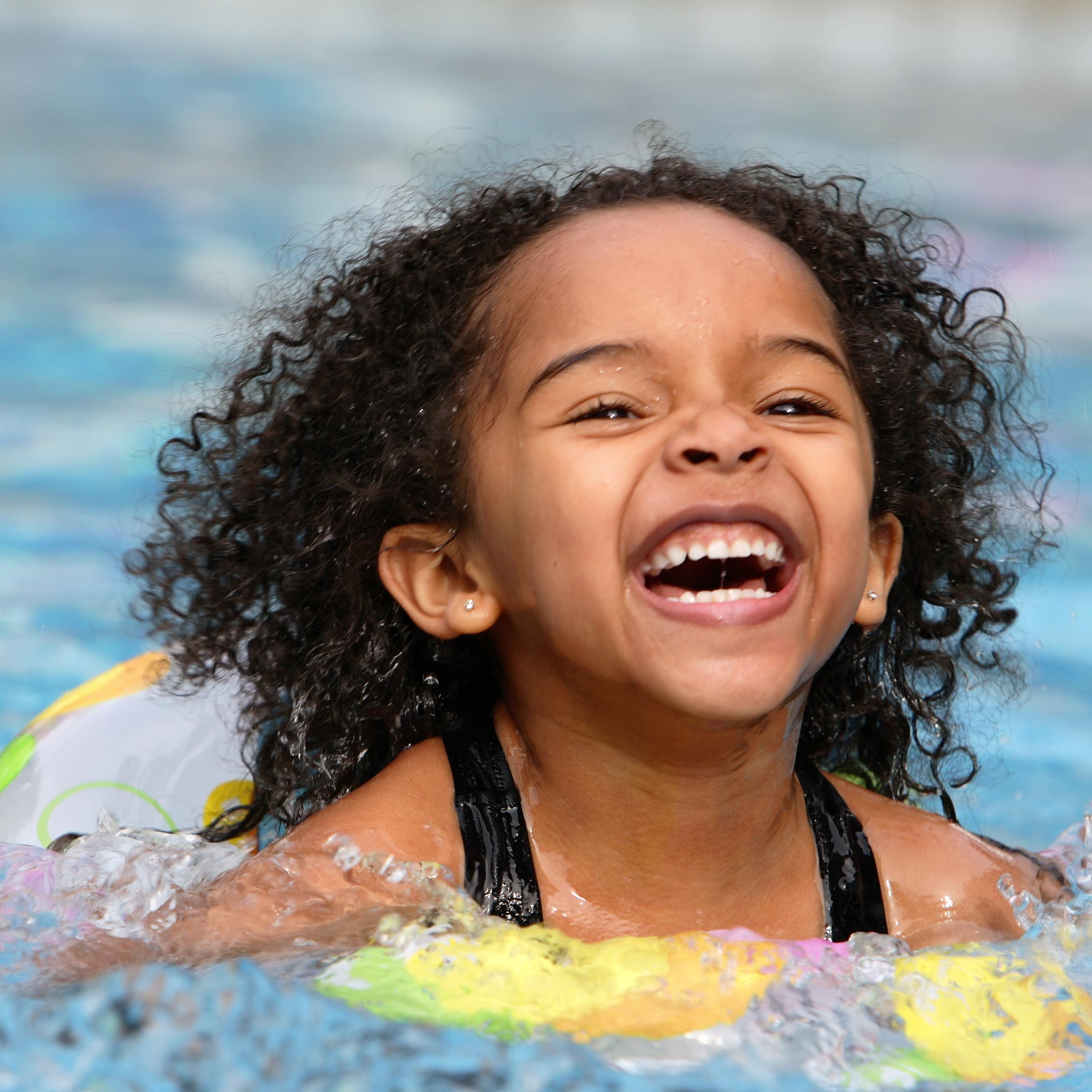 Little girl with floaties swimming in a pool